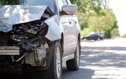 damaged car on side of road after hit and run accident